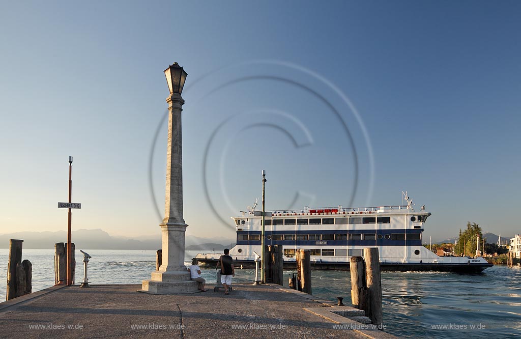 Peschiera, Abenstimmung mit Blick ueber die Hafenmole mit Leuchtmast und Faehrschiff Brescia im stimmungsvollen Abendlicht; Peschiera view over the mole with lightmast and ferry ship Brescia in evening light