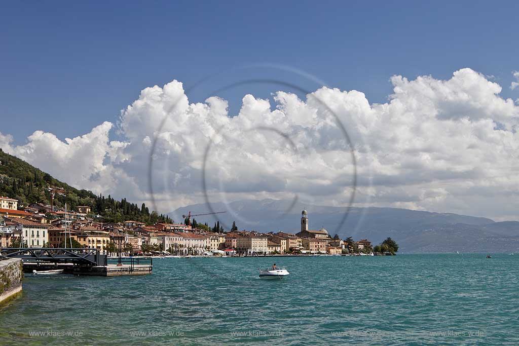 Salo, Blick von der wohl schoensten und laengsten Uferpromenade das Gardasees zur Stadt mit dem einzigen Dom am Gardasee, dem Santa Maria Annunziata, im Hintergrund das Monte Baldo massiv mit kraeftigen Kumulus Wolken; Salo view onto Salo with the beatiful promanade, city with dome St. Maria Annunziata, and Monto Baldo mass in the background. 