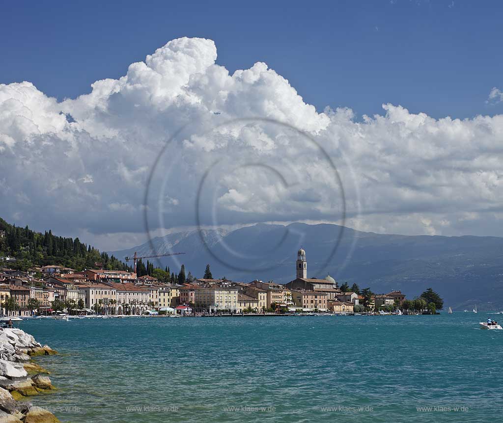 Salo, Blick von der wohl schoensten und laengsten Uferpromenade das Gardasees zur Stadt mit dem einzigen Dom am Gardasee, dem Santa Maria Annunziata, im Hintergrund das Monte Baldo massiv mit kraeftigen Kumulus Wolken; Salo view onto Salo with the beatiful promanade, city with dome St. Maria Annunziata, and Monto Baldo mass in the background. 