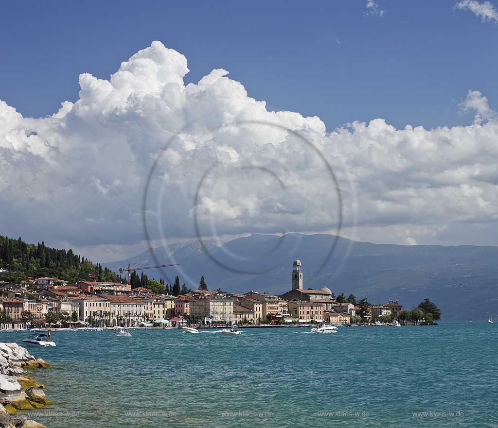 Salo, Blick von der wohl schoensten und laengsten Uferpromenade das Gardasees zur Stadt mit dem einzigen Dom am Gardasee, dem Santa Maria Annunziata, im Hintergrund das Monte Baldo massiv mit kraeftigen Kumulus Wolken; Salo view onto Salo with the beatiful promanade, city with dome St. Maria Annunziata, and Monto Baldo mass in the background. 
