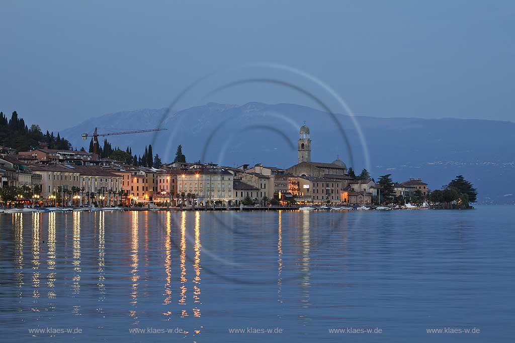 Salo, Blick von der wohl schoensten und laengsten Uferpromenade das Gardasees zur Stadt mit dem einzigen Dom am Gardasee, dem Santa Maria Annunziata, im Hintergrund das Monte Baldo massiv zur blauen Stunde; Salo view onto Salo with the beatiful promanade, city with dome St. Maria Annunziata, and Monto Baldo massduring blue hour.