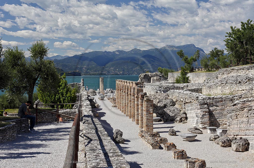 Sirmione, die Grotten des Katull, imposante Ueberreste einer roemischen Villa  aus dem 1. Jahrhundert vor Christi, Landschaft mit Ruinen, mit Gardasee und Bergen im Hintergrund; Sirmione, the Caves of Catullus, impressive remains of a Roman villa, 1th Century A.D. landscape with Lake Garda and mountains in the background; Sirmione Le Grotte di Catullo, imponenti resti una villa romana 1 sec. d.C.