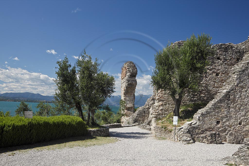 Sirmione, die Grotten des Katull, imposante Ueberreste einer roemischen Villa  aus dem 1. Jahrhundert vor Christi, Landschaft mit Ruinen, mit Gardasee und Bergen im Hintergrund; Sirmione, the Caves of Catullus, impressive remains of a Roman villa, 1th Century A.D. landscape with Lake Garda and mountains in the background; Sirmione Le Grotte di Catullo, imponenti resti una villa romana 1 sec. d.C.