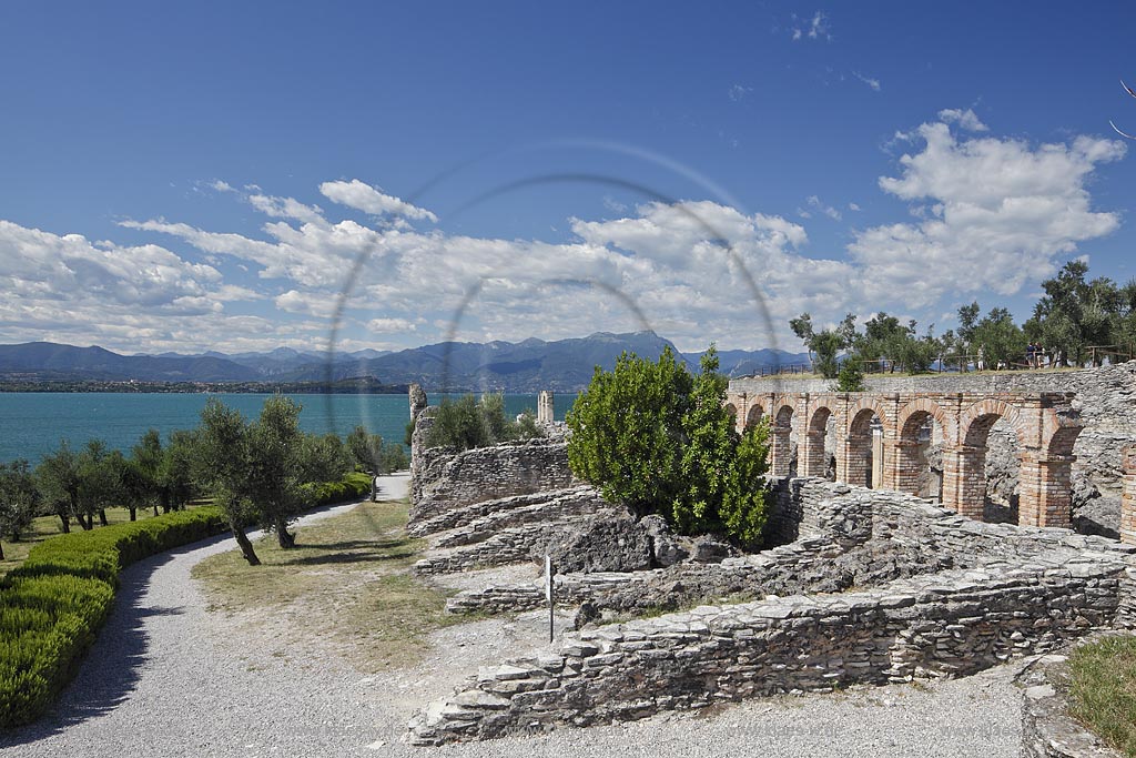 Sirmione, die Grotten des Katull, imposante Ueberreste einer roemischen Villa  aus dem 1. Jahrhundert vor Christi, Landschaft mit Ruinen, mit Gardasee und Bergen im Hintergrund; Sirmione, the Caves of Catullus, impressive remains of a Roman villa, 1th Century A.D. landscape with Lake Garda and mountains in the background; Sirmione Le Grotte di Catullo, imponenti resti una villa romana 1 sec. d.C.