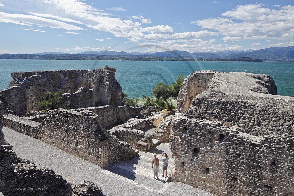 Sirmione, die Grotten des Katull, imposante Ueberreste einer roemischen Villa  aus dem 1. Jahrhundert vor Christi, Landschaft mit Ruinen, mit Gardasee und Bergen im Hintergrund; Sirmione, the Caves of Catullus, impressive remains of a Roman villa, 1th Century A.D. landscape with Lake Garda and mountains in the background; Sirmione Le Grotte di Catullo, imponenti resti una villa romana 1 sec. d.C.