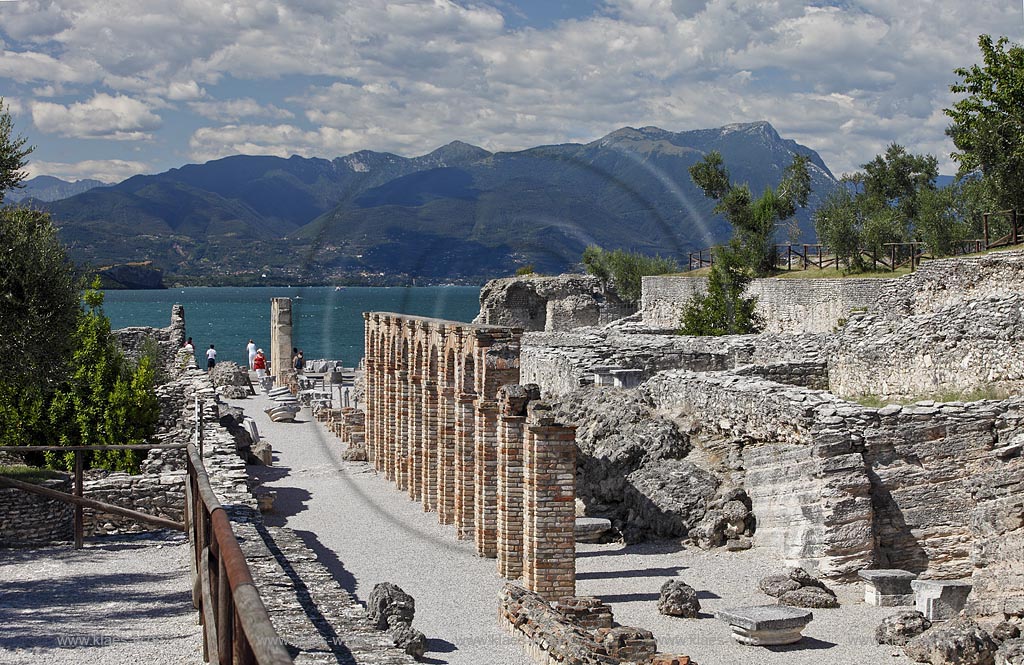 Sirmione, die Grotten des Katull, imposante Ueberreste einer roemischen Villa  aus dem 1. Jahrhundert vor Christi, Landschaft mit Ruinen, mit Gardasee und Bergen im Hintergrund; Sirmione, the Caves of Catullus, impressive remains of a Roman villa, 1th Century A.D. landscape with Lake Garda and mountains in the background; Sirmione Le Grotte di Catullo, imponenti resti una villa romana 1 sec. d.C.