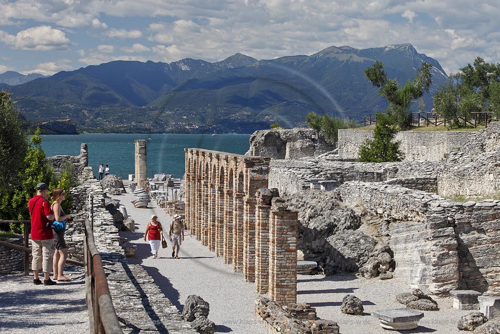 Sirmione, die Grotten des Katull, imposante Ueberreste einer roemischen Villa  aus dem 1. Jahrhundert vor Christi, Landschaft mit Ruinen, mit Gardasee und Bergen im Hintergrund; Sirmione, the Caves of Catullus, impressive remains of a Roman villa, 1th Century A.D. landscape with Lake Garda and mountains in the background; Sirmione Le Grotte di Catullo, imponenti resti una villa romana 1 sec. d.C.