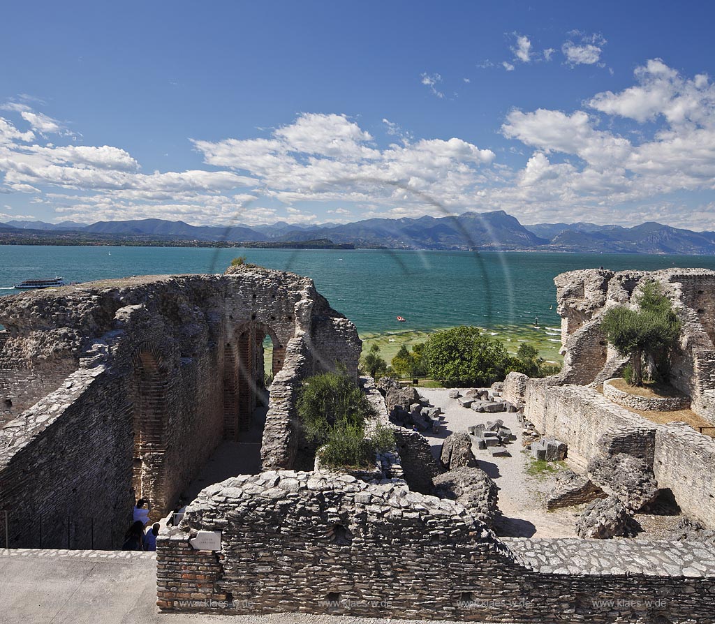 Sirmione, die Grotten des Katull, imposante Ueberreste einer roemischen Villa  aus dem 1. Jahrhundert vor Christi, Landschaft mit Ruinen, mit Gardasee und Bergen im Hintergrund; Sirmione, the Caves of Catullus, impressive remains of a Roman villa, 1th Century A.D. landscape with Lake Garda and mountains in the background; Sirmione Le Grotte di Catullo, imponenti resti una villa romana 1 sec. d.C.