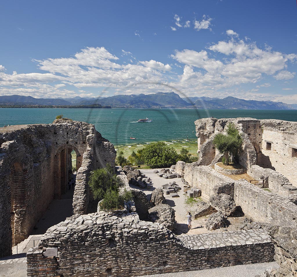 Sirmione, die Grotten des Katull, imposante Ueberreste einer roemischen Villa  aus dem 1. Jahrhundert vor Christi, Landschaft mit Ruinen, mit Gardasee und Bergen im Hintergrund; Sirmione, the Caves of Catullus, impressive remains of a Roman villa, 1th Century A.D. landscape with Lake Garda and mountains in the background; Sirmione Le Grotte di Catullo, imponenti resti una villa romana 1 sec. d.C.