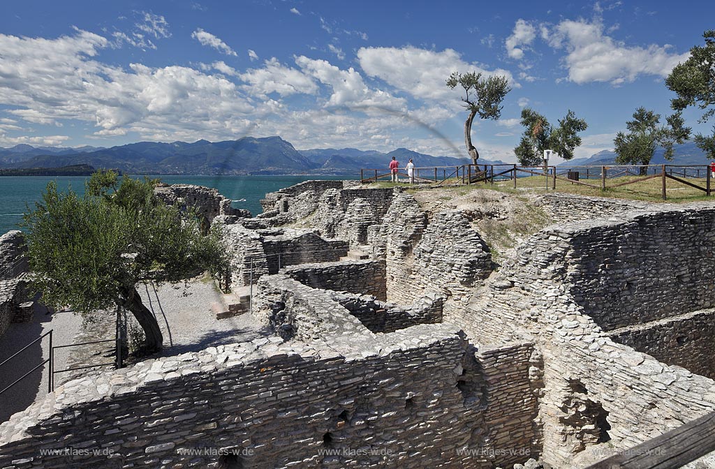 Sirmione, die Grotten des Katull, imposante Ueberreste einer roemischen Villa  aus dem 1. Jahrhundert vor Christi, Landschaft mit Ruinen, mit Gardasee und Bergen im Hintergrund; Sirmione, the Caves of Catullus, impressive remains of a Roman villa, 1th Century A.D. landscape with Lake Garda and mountains in the background; Sirmione Le Grotte di Catullo, imponenti resti una villa romana 1 sec. d.C.