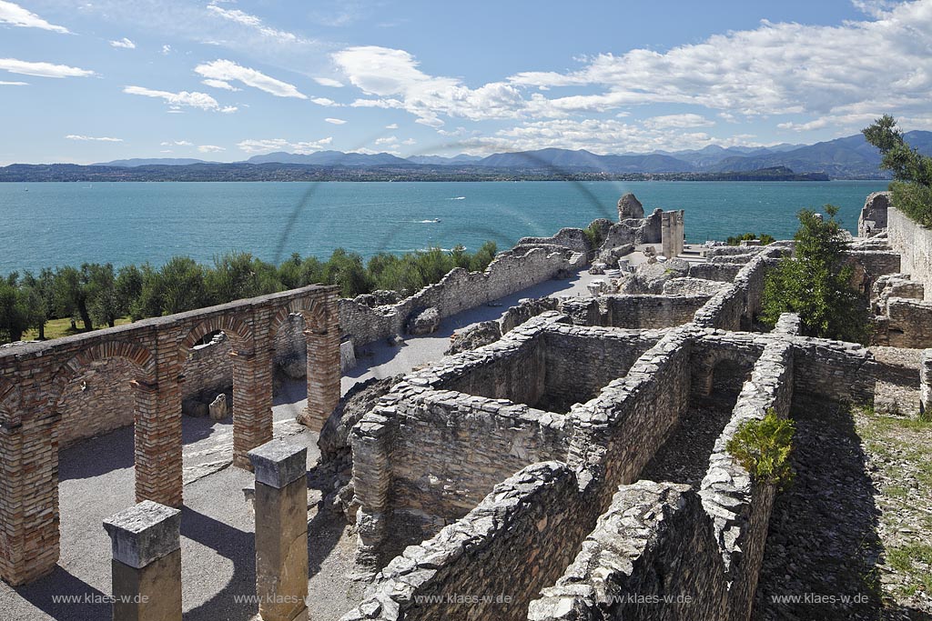 Sirmione, die Grotten des Katull, imposante Ueberreste einer roemischen Villa  aus dem 1. Jahrhundert vor Christi, Landschaft mit Ruinen, mit Gardasee und Bergen im Hintergrund; Sirmione, the Caves of Catullus, impressive remains of a Roman villa, 1th Century A.D. landscape with Lake Garda and mountains in the background; Sirmione Le Grotte di Catullo, imponenti resti una villa romana 1 sec. d.C.