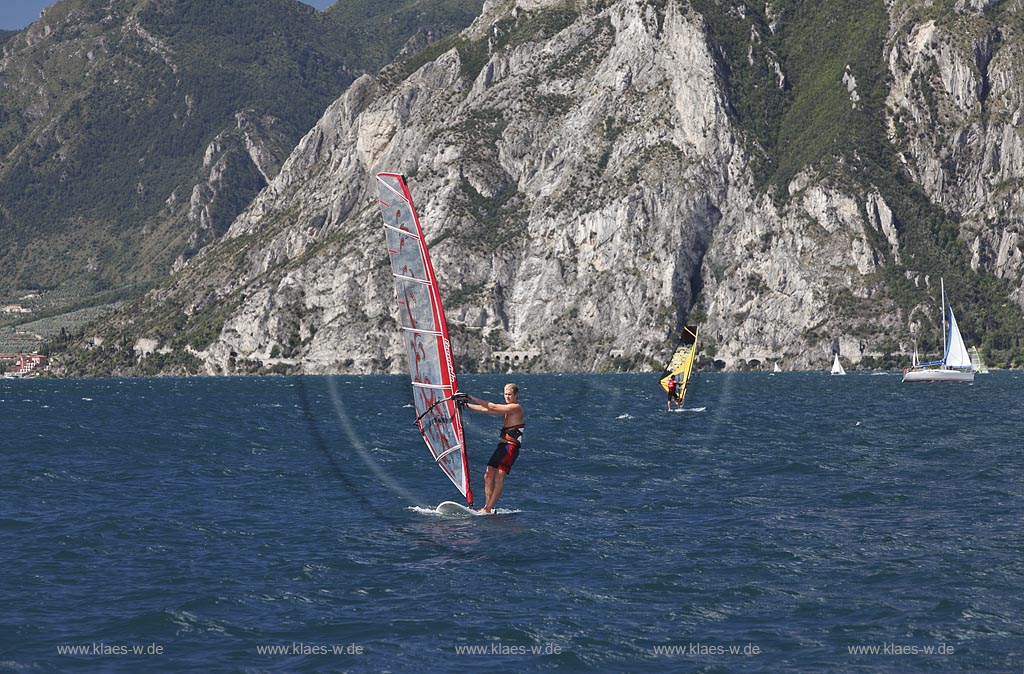 Torbole sul Garda, Circolo Velo Torbole, Blick ueber den Gardasee mit Surfern und  Bergkulisse im Hintergrund, tuerkis schimmernde Wasseroberflaeche, windig; Torbole sul Garda, Circolo Velo Torbole, view over the Lake Garda with wind surfers and mountains in the background, windy