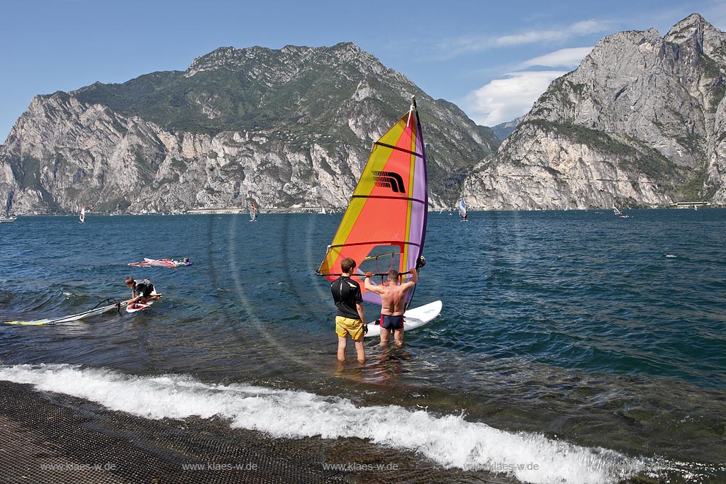 Torbole sul Garda, Circolo Velo Torbole, Blick ueber den Gardasee mit Surfern und  Bergkulisse im Hintergrund, tuerkis schimmernde Wasseroberflaeche, windig; Torbole sul Garda, Circolo Velo Torbole, view over the Lake Garda with wind surfers and mountains in the background, windy