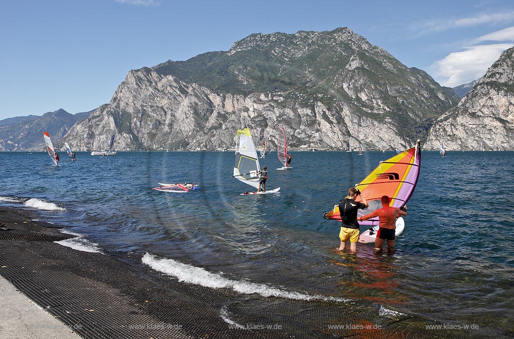 Torbole sul Garda, Circolo Velo Torbole, Blick ueber den Gardasee mit Surfern und  Bergkulisse im Hintergrund, tuerkis schimmernde Wasseroberflaeche, windig; Torbole sul Garda, Circolo Velo Torbole, view over the Lake Garda with wind surfers and mountains in the background, windy