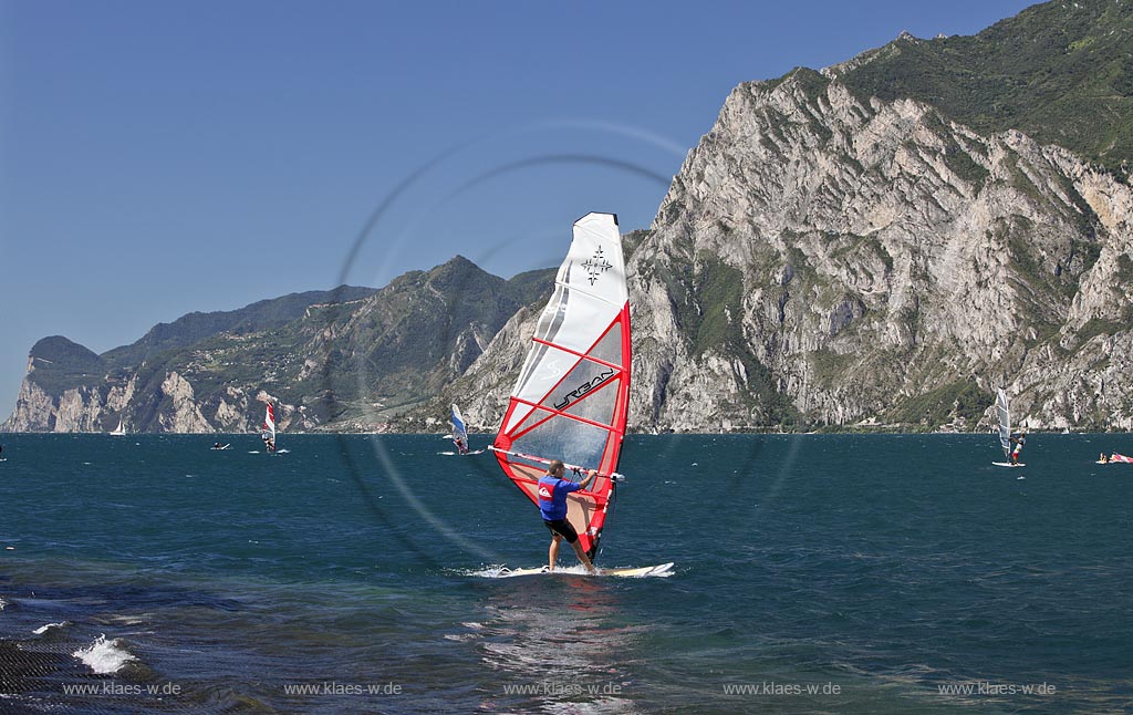 Torbole sul Garda, Circolo Velo Torbole, Blick ueber den Gardasee mit Surfern und  Bergkulisse im Hintergrund, tuerkis schimmernde Wasseroberflaeche, windig; Torbole sul Garda, Circolo Velo Torbole, view over the Lake Garda with wind surfers and mountains in the background, windy