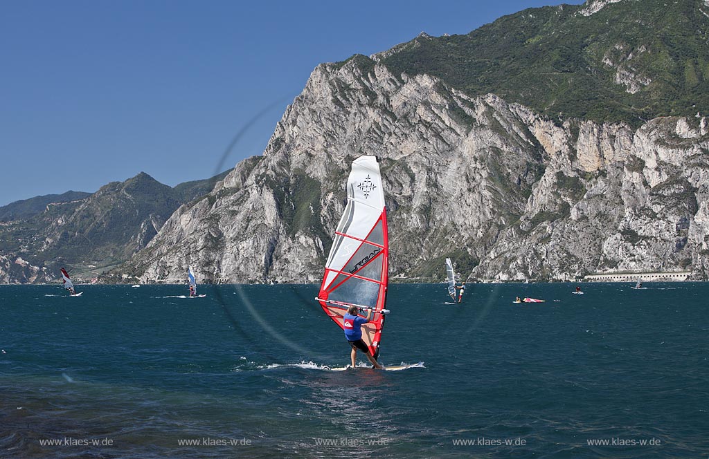 Torbole sul Garda, Circolo Velo Torbole, Blick ueber den Gardasee mit Surfern und  Bergkulisse im Hintergrund, tuerkis schimmernde Wasseroberflaeche, windig; Torbole sul Garda, Circolo Velo Torbole, view over the Lake Garda with wind surfers and mountains in the background, windy
