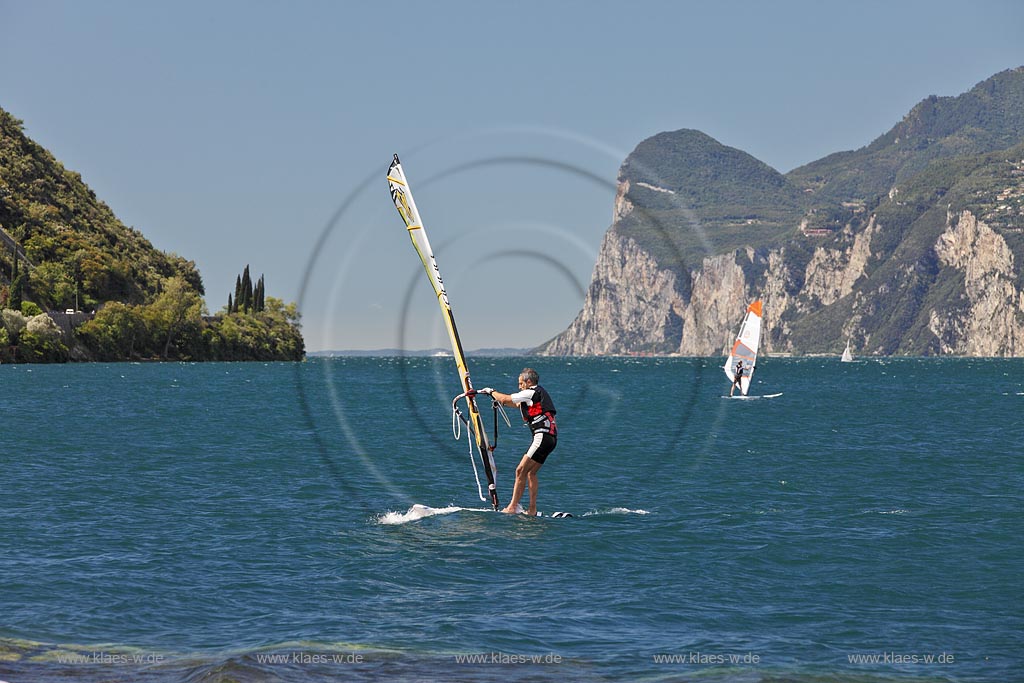 Torbole sul Garda, Circolo Velo Torbole, Blick ueber den Gardasee mit Surfern und  Bergkulisse im Hintergrund, tuerkis schimmernde Wasseroberflaeche, windig; Torbole sul Garda, Circolo Velo Torbole, view over the Lake Garda with wind surfers and mountains in the background, windy