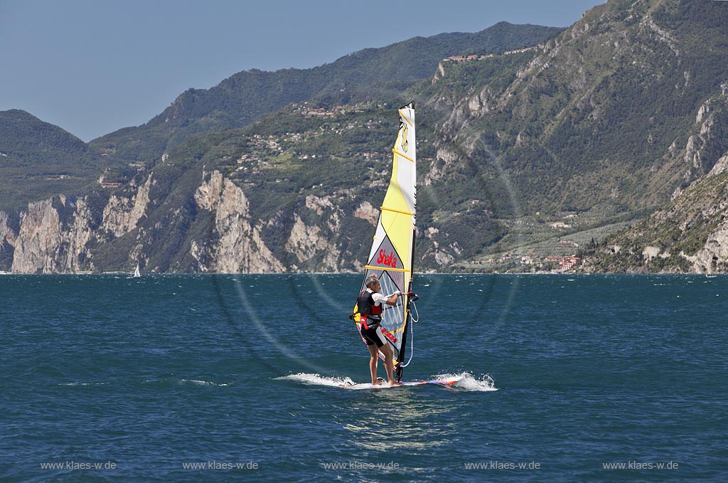 Torbole sul Garda, Circolo Velo Torbole, Blick ueber den Gardasee mit Surfern und  Bergkulisse im Hintergrund, tuerkis schimmernde Wasseroberflaeche, windig; Torbole sul Garda, Circolo Velo Torbole, view over the Lake Garda with wind surfers and mountains in the background, windy