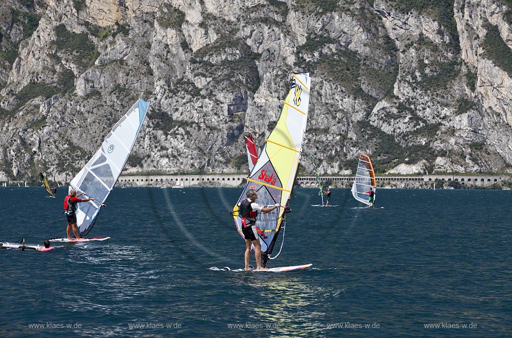 Torbole sul Garda, Circolo Velo Torbole, Blick ueber den Gardasee mit Surfern und  Bergkulisse im Hintergrund, tuerkis schimmernde Wasseroberflaeche, windig; Torbole sul Garda, Circolo Velo Torbole, view over the Lake Garda with wind surfers and mountains in the background, windy