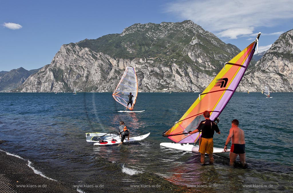Torbole sul Garda, Circolo Velo Torbole, Blick ueber den Gardasee mit Surfern und  Bergkulisse im Hintergrund, tuerkis schimmernde Wasseroberflaeche, windig; Torbole sul Garda, Circolo Velo Torbole, view over the Lake Garda with wind surfers and mountains in the background, windy