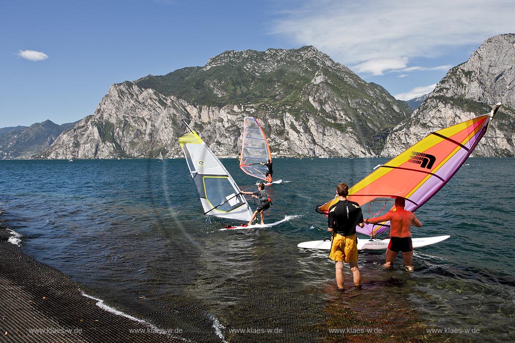 Torbole sul Garda, Circolo Velo Torbole, Blick ueber den Gardasee mit Surfern und  Bergkulisse im Hintergrund, tuerkis schimmernde Wasseroberflaeche, windig; Torbole sul Garda, Circolo Velo Torbole, view over the Lake Garda with wind surfers and mountains in the background, windy