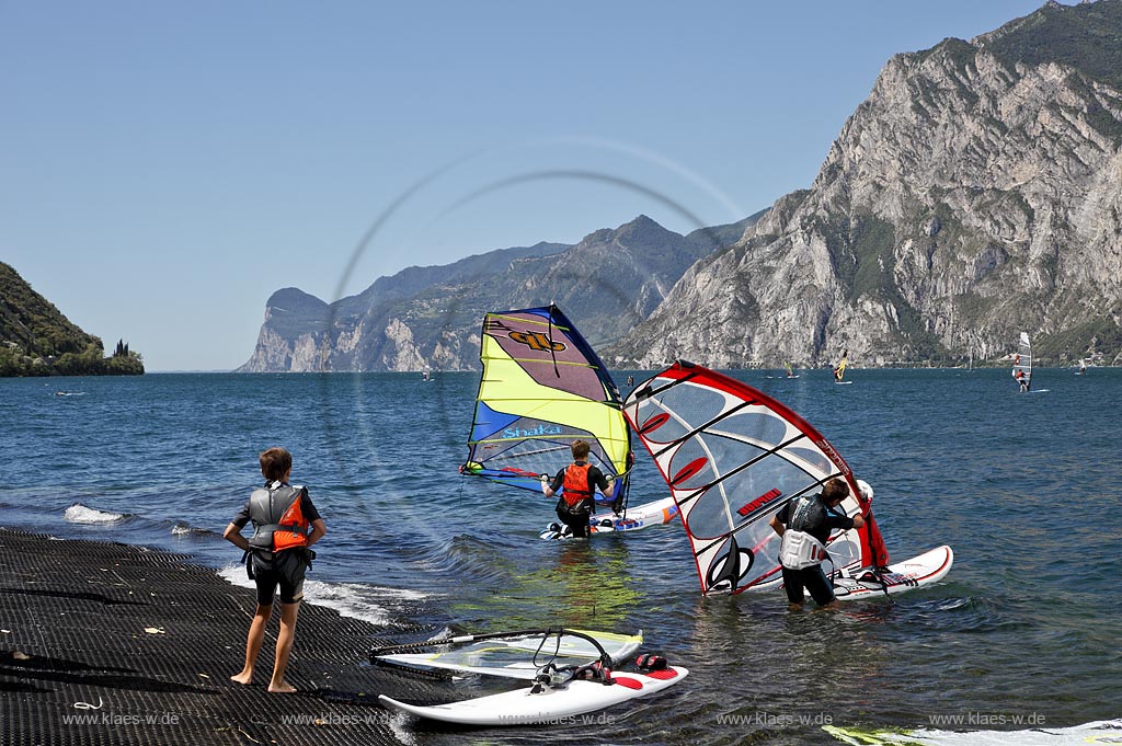 Torbole sul Garda, Circolo Velo Torbole, Blick ueber den Gardasee mit Surfern und  Bergkulisse im Hintergrund, tuerkis schimmernde Wasseroberflaeche, windig; Torbole sul Garda, Circolo Velo Torbole, view over the Lake Garda with wind surfers and mountains in the background, windy