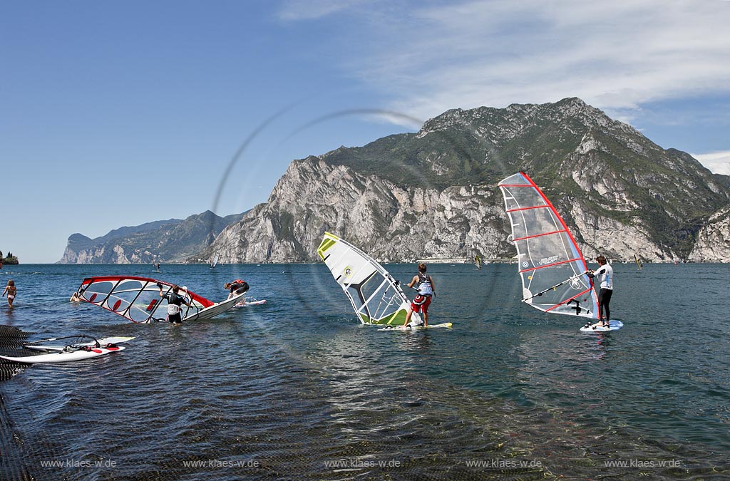 Torbole sul Garda, Circolo Velo Torbole, Blick ueber den Gardasee mit Surfern und  Bergkulisse im Hintergrund, tuerkis schimmernde Wasseroberflaeche, windig; Torbole sul Garda, Circolo Velo Torbole, view over the Lake Garda with wind surfers and mountains in the background, windy