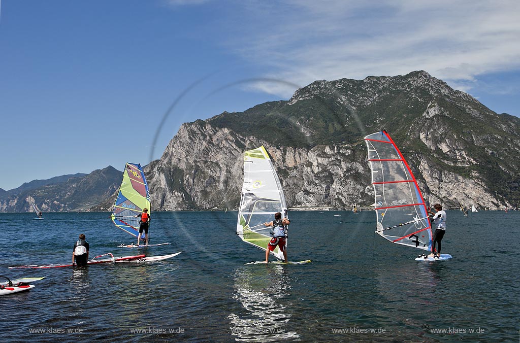 Torbole sul Garda, Circolo Velo Torbole, Blick ueber den Gardasee mit Surfern und  Bergkulisse im Hintergrund, tuerkis schimmernde Wasseroberflaeche, windig; Torbole sul Garda, Circolo Velo Torbole, view over the Lake Garda with wind surfers and mountains in the background, windy