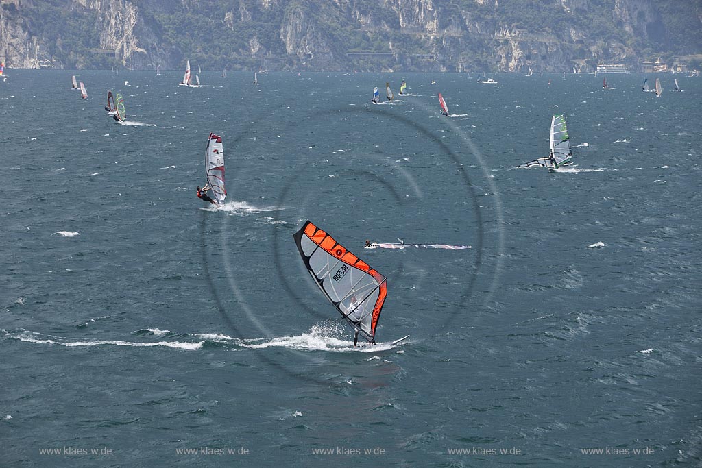 Torbole sul Garda, Blick ueber den Gardasee mit Surfern und  Bergpanorama im Hinterkulisse, tuerkis schimmernde Wasseroberflaeche, stuermisch; Torbole sul Garda, view over the Lake Garda with wind surfers and mountains in the background, impressive clouds atmosphere, stormy wind