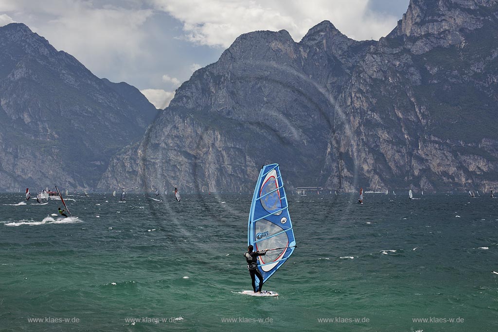 Torbole sul Garda, Blick ueber den Gardasee mit Surfern und  Bergpanorama im Hinterkulisse, tuerkis schimmernde Wasseroberflaeche, stuermisch; Torbole sul Garda, view over the Lake Garda with wind surfers and mountains in the background, impressive clouds atmosphere, stormy wind