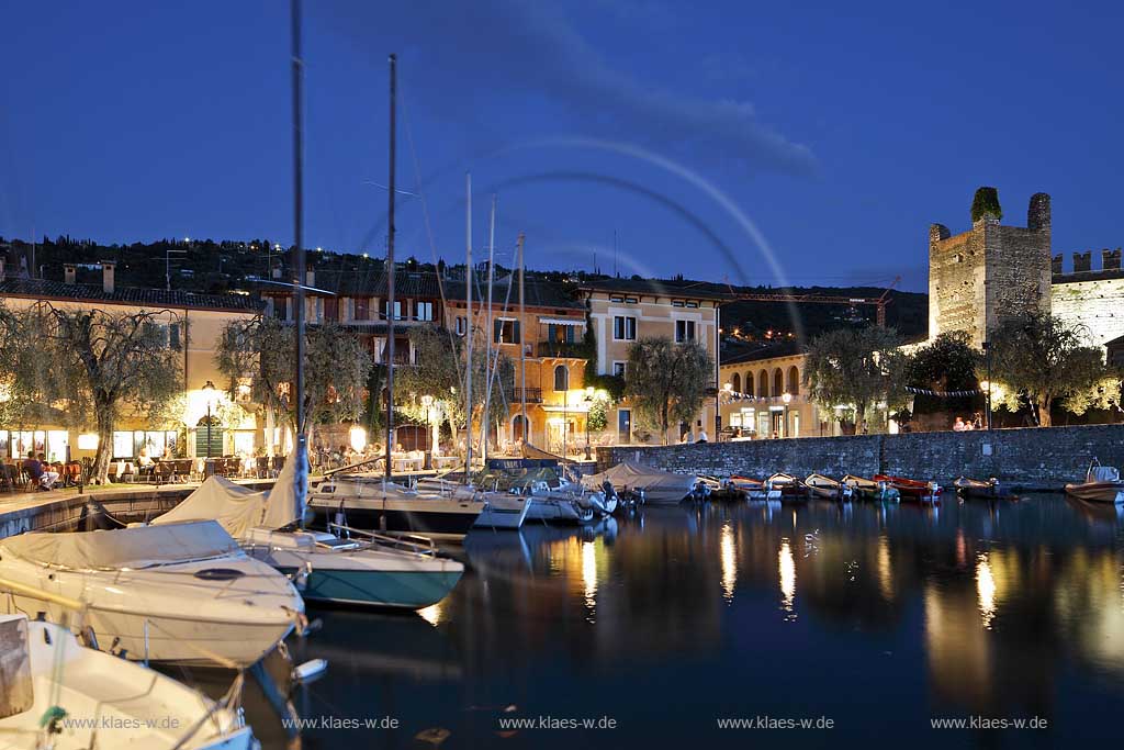 Torri del Benaco, Blick ueber den Hafen zum Ort mit Turm der Scaliger Burg rechts im Bild zur blauen Stunde, illuminiert; Torri del Benaco, view over the port to the centre with a tower of Scaliger castle, right side during blue hour, illuminated