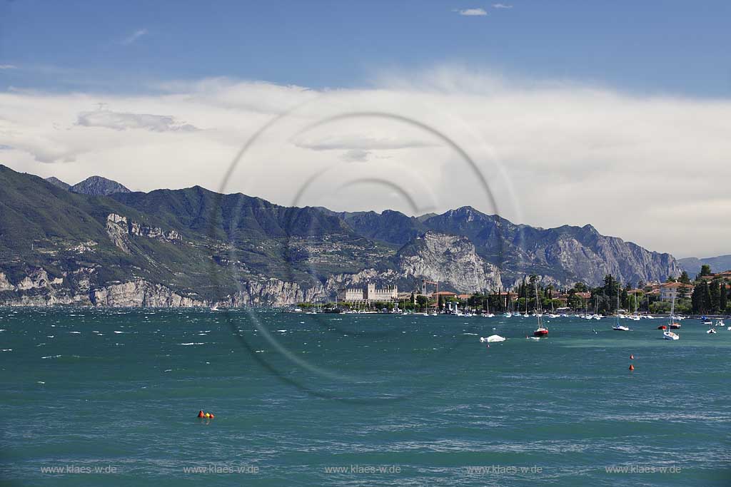 Torri del Benaco, Blick ueber den Gardasee bei Sturm mit Wellengang zur Scaliger Burg, im Hintergrund das Bergpanorama mit der Hochebene von Tignale und Tremosine; Torri del Benaco, view over lake Garda with waves on a stormy day to the Scaliger castle, in the Background the panorama of mountains with tableland of Tignale and Tremosine