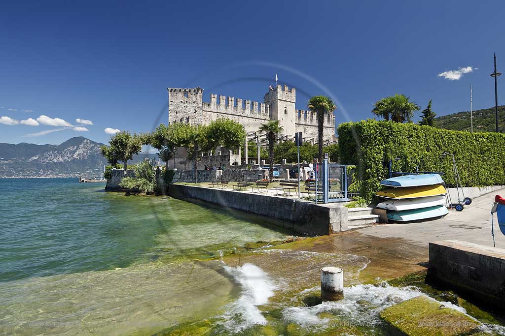 Torri del Benaco, Blick vom Gadasee Ufer mit klarem Wasser und Wellen zur Scaliger Burg; Torri del Benaco, view from lakefront with clear water and waves to the Scaliger castle 