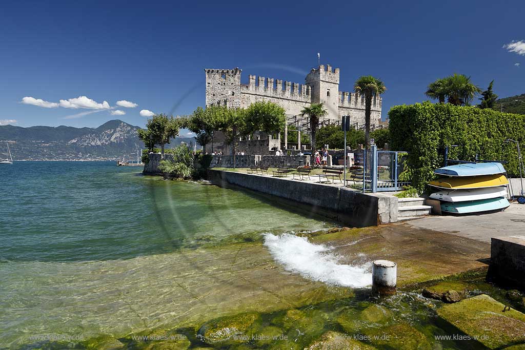 Torri del Benaco, Blick vom Gadasee Ufer mit klarem Wasser und Wellen zur Scaliger Burg; Torri del Benaco, view from lakefront with clear water and waves to the Scaliger castle 