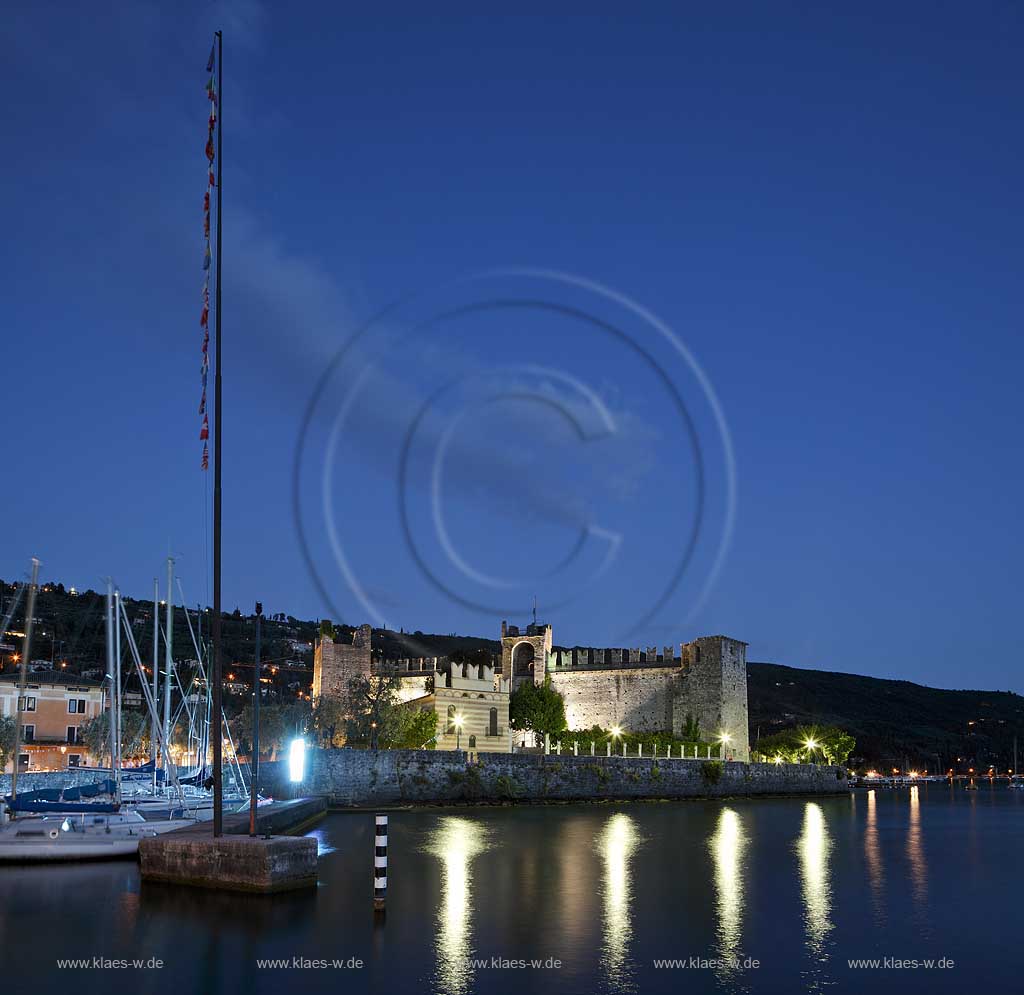 Torri del Banco, Blick vom Hafen mit Segelbooten und Gardasee zur Scaliger Burg waehrend der blauen Stunde; Torri del Benaco, view from port with sailboats and Lake Garda to the Scaliger castle during blue hour