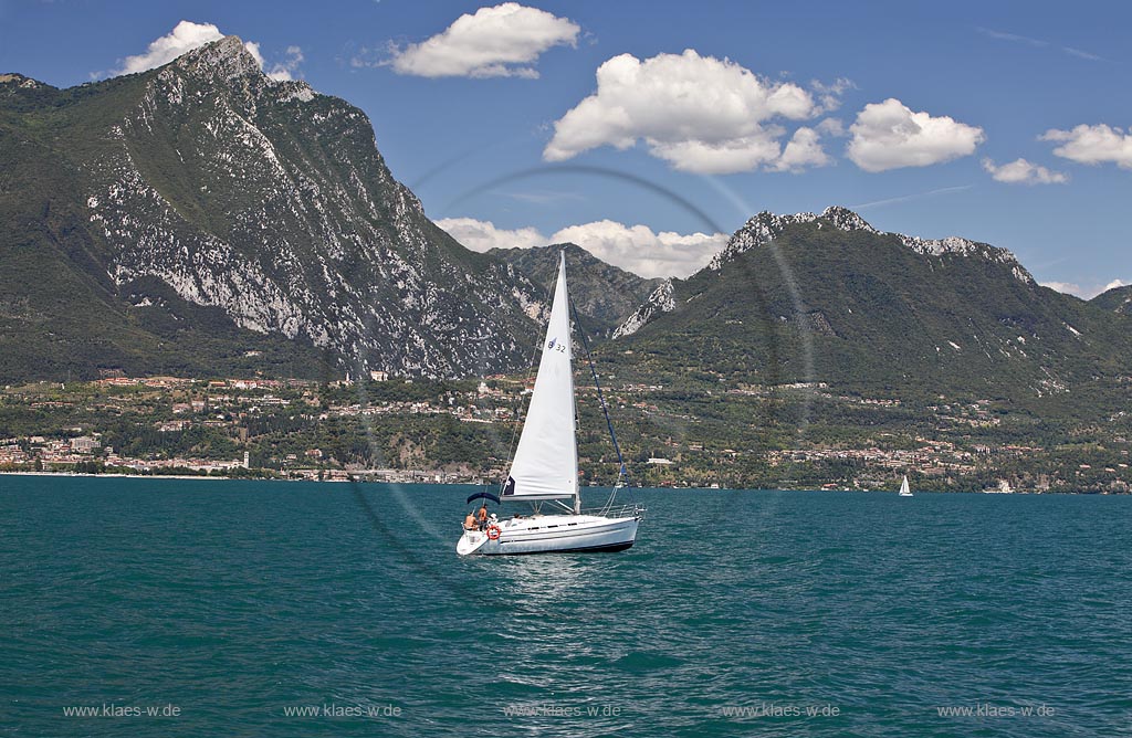 Monte Pizzocolo und Monte Castello mit Toscolano-Maderno, Blick vom Seemit Segelboot im Vordergrund zu den Bergen mit Toscolano Maderno; Mone Pizzocolo with Monte Castello, view to the mountains with Toscolano-Maderno from lake Garda with a sailboat in the foreground