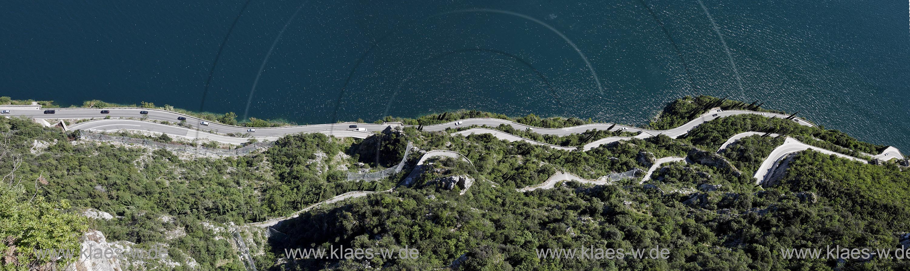 Tremosine-Pieve, Blick von der Schauderterasse, der legendaeren Terazza del Brivido senkrecht nach unten auf die Serpentinen der Gardasee Strasse mit Autos, Landschaft und See; Tremosine-Pieve; view from Terazza del Brivido in Pieve looking down to twisting road, winding road with cars, landscape and Lake garda