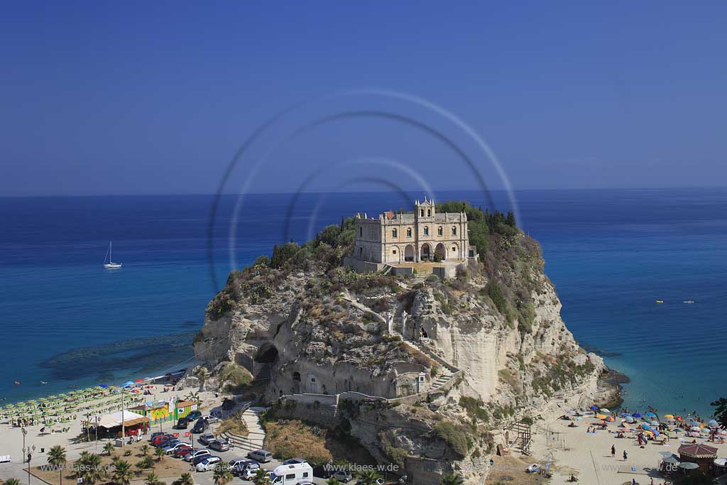 Blick auf die auf einem Felsen gelegene Wallfahrtskirche Chiesa Santa Maria dell'Isola in Tropea, Kalabrien, Italien mit Sicht auf das Meer und Menschen, Touristen am Strand