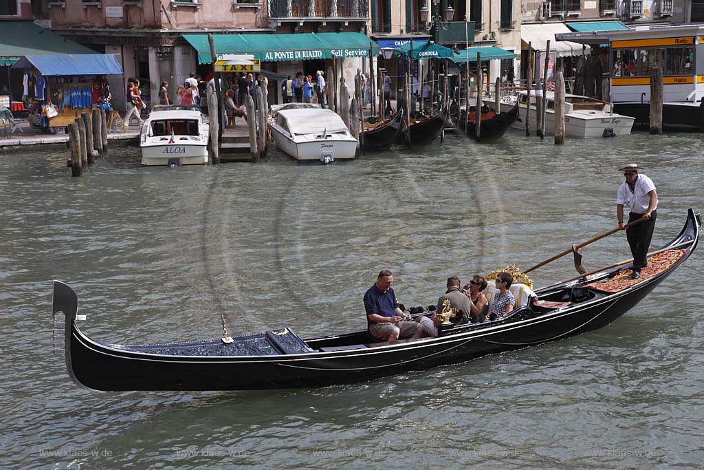 Venedig, Rialto, Canal Grande, Gondel mit Gondoliere Abbildung von vorne weisses Hemd und Hut, zwei Paare in Gondel sitzend; Venice Rialto Canal Grande gondola with gondolier with hut, two couple sitting in the gondola