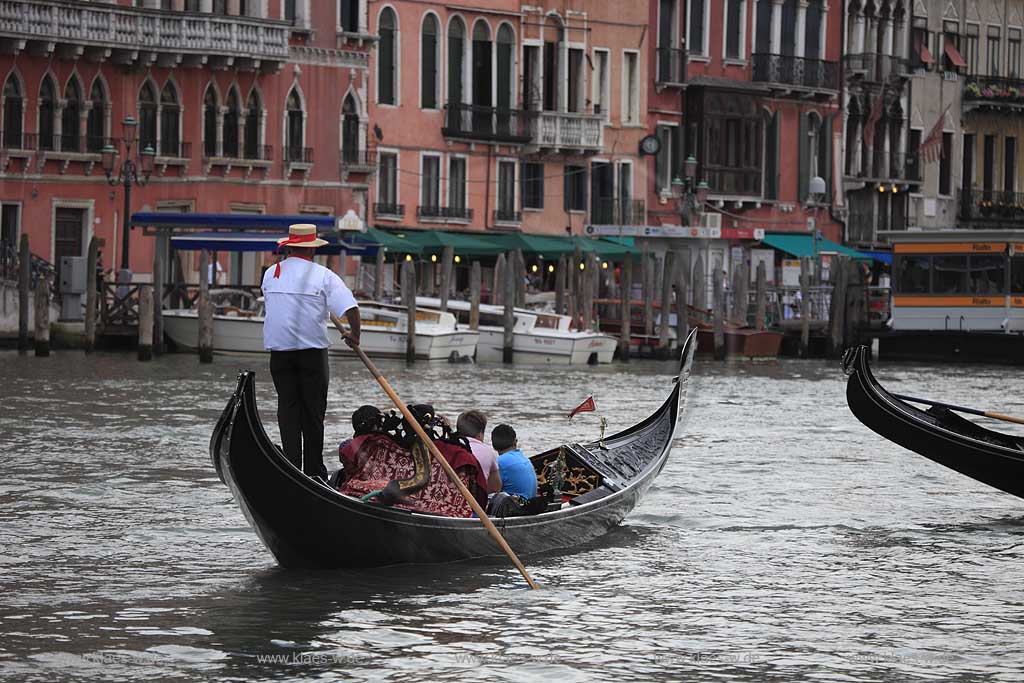 Venedig, Rialto, Canal Grande, Gondel mit Gondoliere Abbildung von hinten weisses Hemd und Hut, vier Personen in Gondel sitzend; Venice Rialto Canal Grande gondola with gondolier with hut four people sitting in the gondola backview