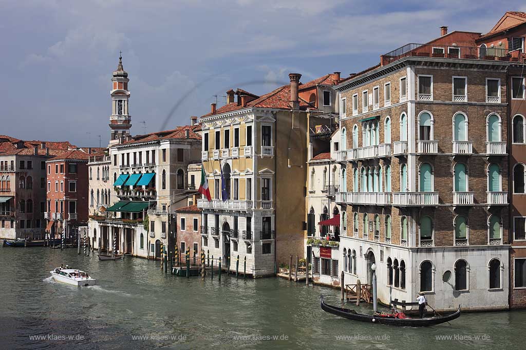 Venedig, Rialto, Blick von Rialto Brcke Ponte di Rialto auf Kanal Grande mit dem Kirchturm der Kirche Chiese dei Santi Apostoli, Palazzo Civran mit Italienfahne und Europafahne, Hotel Al Ponte Antico, mehrere Gondeln mit Gondoliere und Personen in Gondel sitzend; Venice Rialto view from Rialto bride to Canal Grande with tower of church Santi Apostoli, Palazzo Civan with Italianflag and European flag, one gondola and gondolier with young caple sitting in gondola and motorboat
