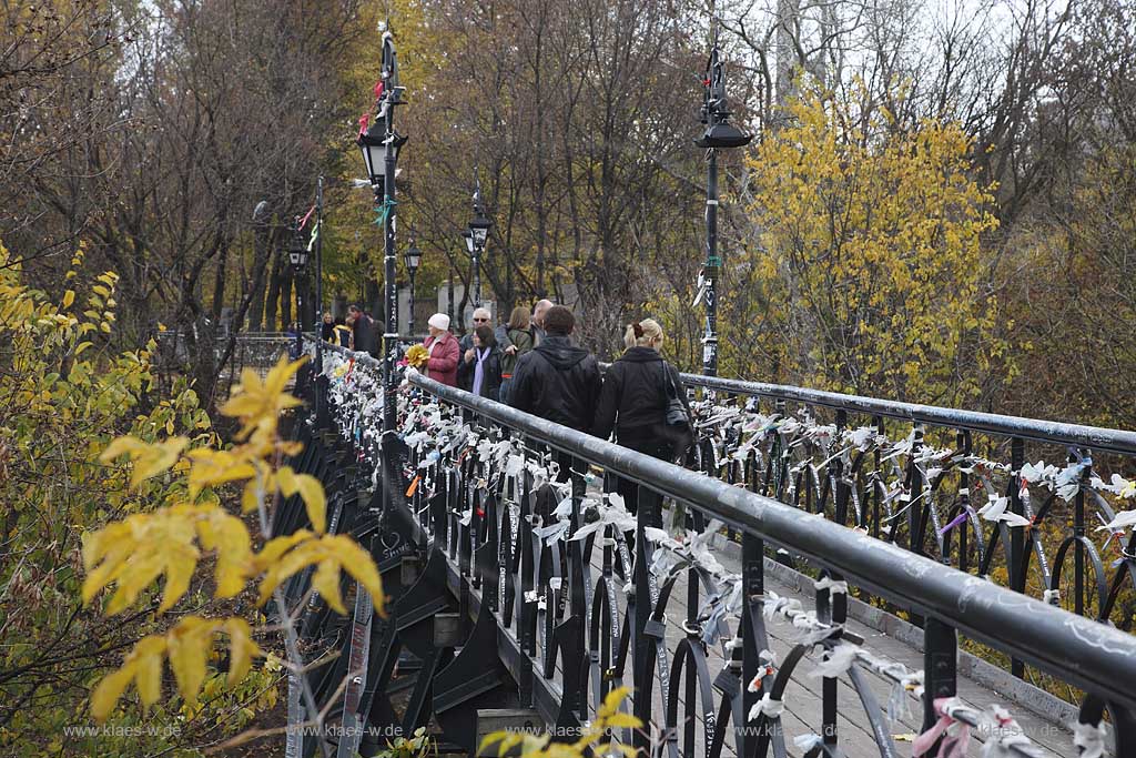 Kiew Parkbruecke oder auch Teufelsbruecke bzw. Bruecke der Verliebten im Chrestschatyj  Chrescatyj Park   Kiew Parkbruecke oder auch Teufelsbruecke bzw. Bruecke der Verliebten im Chrestschatyj  Chrescatyj Park mit Vorhaengeschloessern und Baendern symbolisch von frisch vermaehlten, verheirateten Paaren am gusseisernen Gelaender befestigt . Khreshatyk Gardens with the metal pedestrians bridge known as the Kissing bridge 