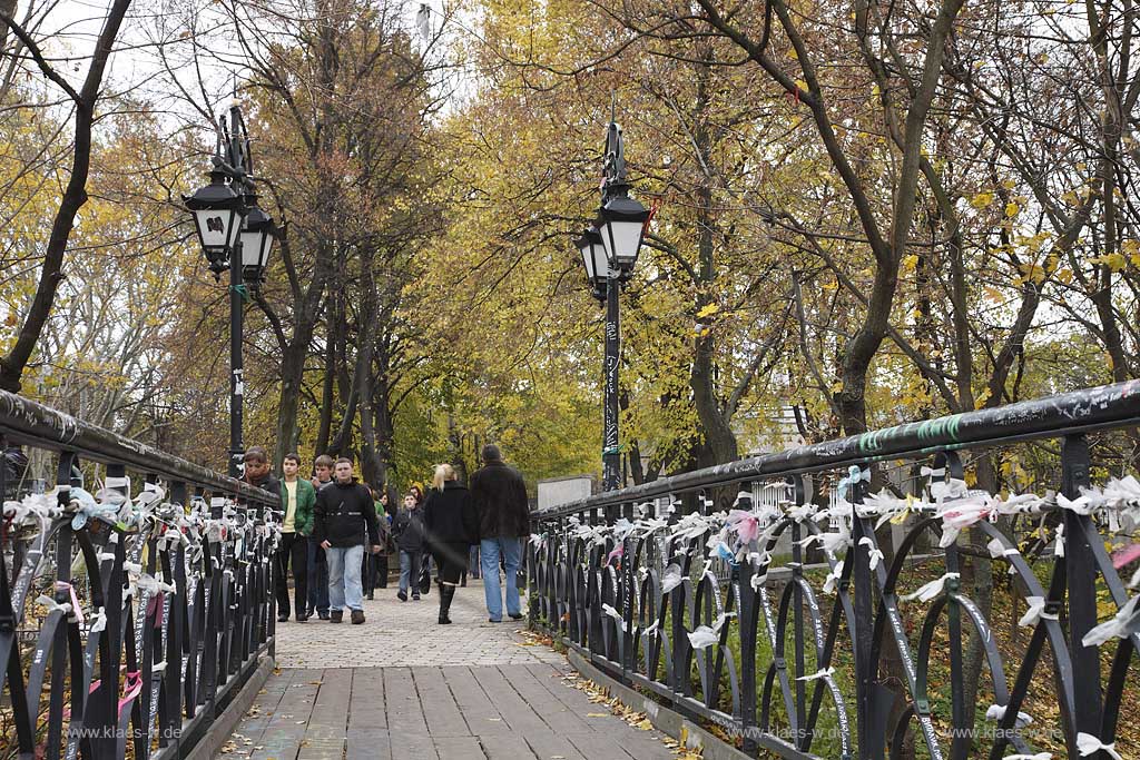 Kiew Parkbruecke oder auch Teufelsbruecke bzw. Bruecke der Verliebten im Chrestschatyj  Chrescatyj Park   Kiew Parkbruecke oder auch Teufelsbruecke bzw. Bruecke der Verliebten im Chrestschatyj  Chrescatyj Park mit Vorhaengeschloessern und Baendern symbolisch von frisch vermaehlten, verheirateten Paaren am gusseisernen Gelaender befestigt . Khreshatyk Gardens with the metal pedestrians bridge known as the Kissing bridge 