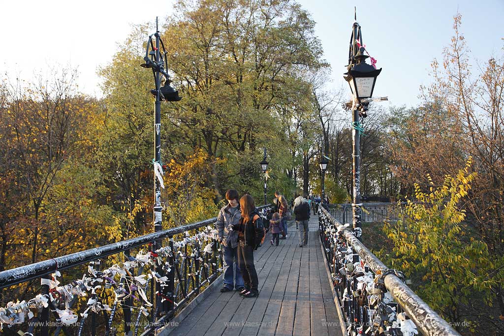 Kiew Parkbruecke oder auch Teufelsbruecke bzw. Bruecke der Verliebten im Chrestschatyj  Chrescatyj Park   Kiew Parkbruecke oder auch Teufelsbruecke bzw. Bruecke der Verliebten im Chrestschatyj  Chrescatyj Park mit Vorhaengeschloessern und Baendern symbolisch von frisch vermaehlten, verheirateten Paaren am gusseisernen Gelaender befestigt . Khreshatyk Gardens with the metal pedestrians bridge known as the Kissing bridge 