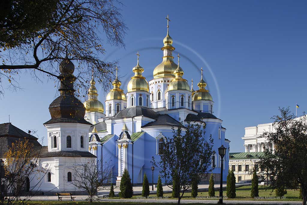 Kiew im Klostergarten des  Michaelskloster Mychajlivs'kyj Zolotoverchyj monasty mit dem Kloster mit den goldenen Kuppeln und der Kirche mit Refektorium vorne links. Ukrainischer Barock. The St. Michael monastery, also spelled St. Michail's, mainly painted azure with a few golden domes on top of it