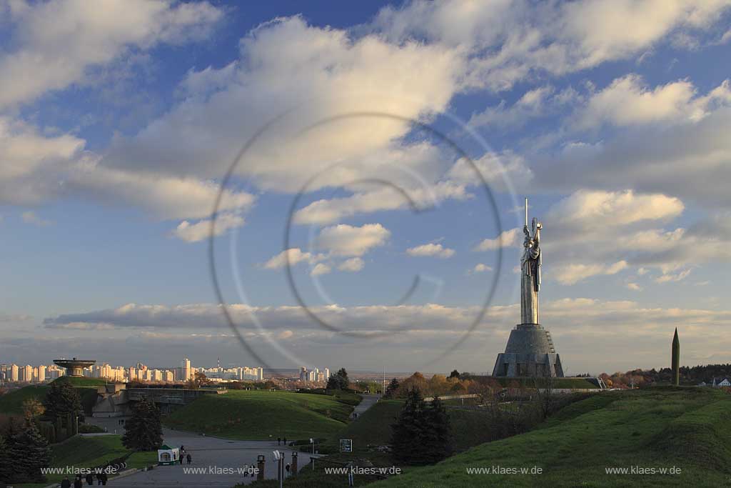 Kiew Statue der Mutter Heimat Rodina mat' mit Schwert und Schild im Park des Ruhmes  aus Metall 108 m hoch einschliesslich Sockel aufgenommen an einem klaren Herbsttag bei tiefstehendem Sonnenlicht stimmungsvoll blauer Himmel mit Wolken . National Museum about the History of the Great Patriotic War against Nazi-Germany with the large monument "Rodina Mat'", lit. 'Mother Home country'. The monument itself is more than 100 m high and reminds the visitor of the devastating but glorious fight against Hitler.