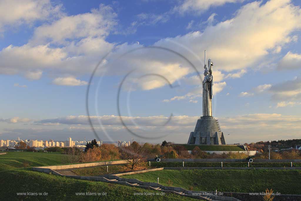 Kiew Statue der Mutter Heimat Rodina mat' mit Schwert und Schild im Park des Ruhmes  aus Metall 108 m hoch einschliesslich Sockel aufgenommen an einem klaren Herbsttag bei tiefstehendem Sonnenlicht stimmungsvoll blauer Himmel mit Wolken . National Museum about the History of the Great Patriotic War against Nazi-Germany with the large monument "Rodina Mat'", lit. 'Mother Home country'. The monument itself is more than 100 m high and reminds the visitor of the devastating but glorious fight against Hitler.