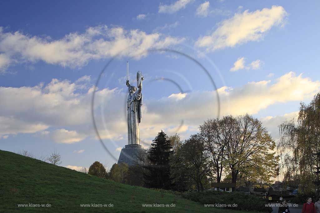 Kiew Statue der Mutter Heimat Rodina mat' mit Schwert und Schild im Park des Ruhmes  aus Metall 108 m hoch einschliesslich Sockel aufgenommen an einem klaren Herbsttag bei tiefstehendem Sonnenlicht stimmungsvoll blauer Himmel mit Wolken . National Museum about the History of the Great Patriotic War against Nazi-Germany with the large monument "Rodina Mat'", lit. 'Mother Home country'. The monument itself is more than 100 m high and reminds the visitor of the devastating but glorious fight against Hitler.