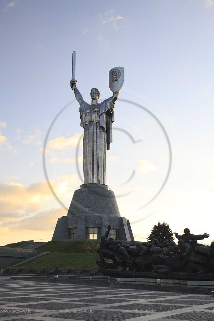 Kiew Statue der Mutter Heimat Rodina mat' mit Schwert und Schild im Park des Ruhmes  aus Metall 108 m hoch einschliesslich Sockel aufgenommen an einem klaren Herbsttag bei tiefstehendem Sonnenlicht stimmungsvoll blauer Himmel mit Wolken . National Museum about the History of the Great Patriotic War against Nazi-Germany with the large monument "Rodina Mat'", lit. 'Mother Home country'. The monument itself is more than 100 m high and reminds the visitor of the devastating but glorious fight against Hitler.