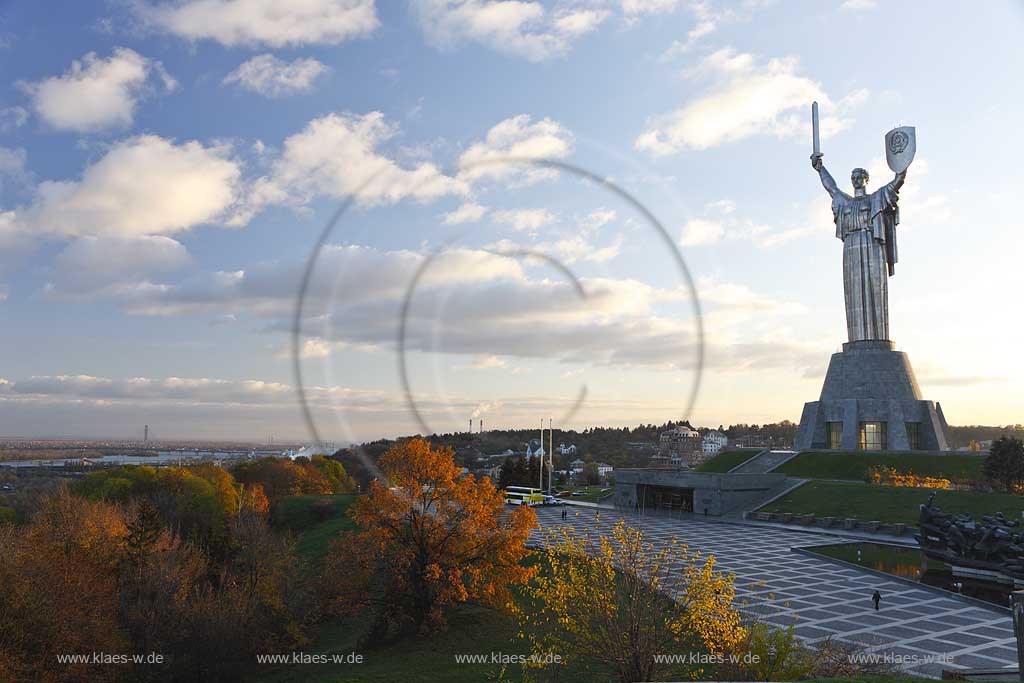 Kiew Statue der Mutter Heimat Rodina mat' mit Schwert und Schild im Park des Ruhmes  aus Metall 108 m hoch einschliesslich Sockel aufgenommen an einem klaren Herbsttag bei tiefstehendem Sonnenlicht stimmungsvoll blauer Himmel mit Wolken . National Museum about the History of the Great Patriotic War against Nazi-Germany with the large monument "Rodina Mat'", lit. 'Mother Home country'. The monument itself is more than 100 m high and reminds the visitor of the devastating but glorious fight against Hitler.